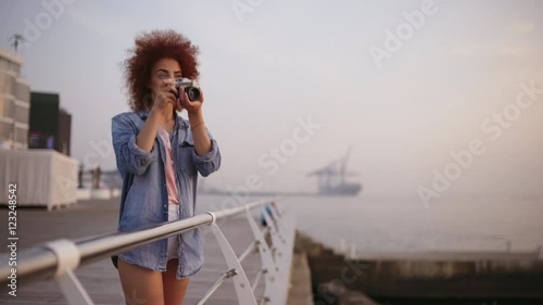 Beautiful female phorograph smiling taking picture at seaside photo