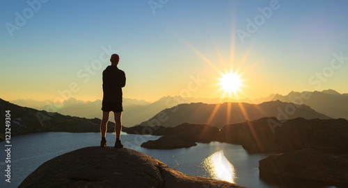Man looking over a lake, Lac Cornu, during sunset.