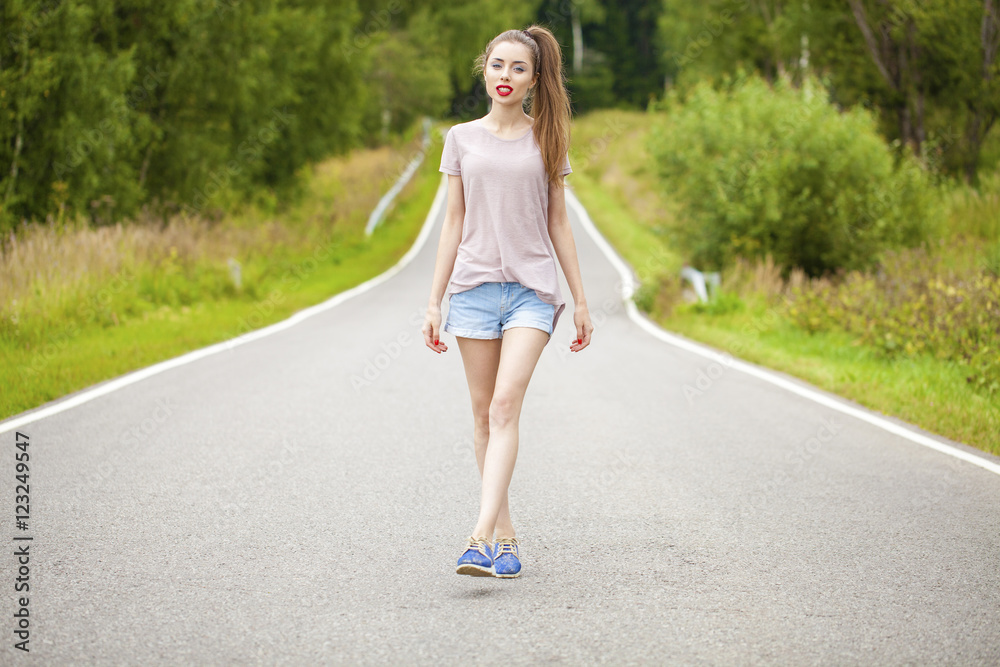 Portrait of young brunette woman in blue jeans short