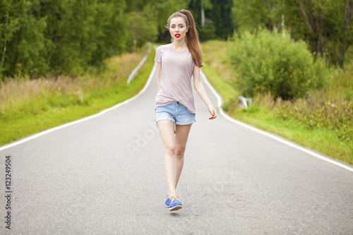 Portrait of young brunette woman in blue jeans short © Andrey_Arkusha