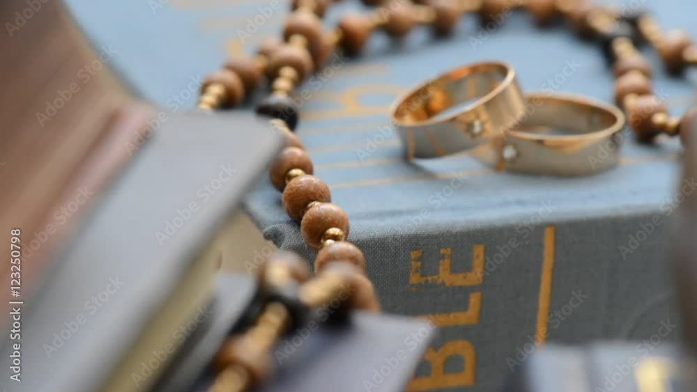 Two wedding rings with cros in the bookshelh, zoom in,shot with slider Two wedding rings with cros in the bookshelh, zoom in,shot with slider