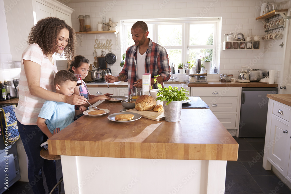 Family At Home Eating Breakfast In Kitchen Together Family At Home Eating Breakfast In Kitchen Together