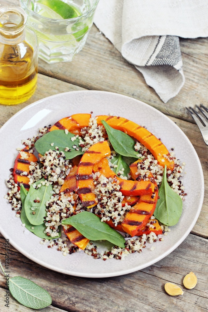 Quinoa salad with grilled pumpkin and fresh spinach on a rustic wooden table.Superfood and clean eating concept. Selective focus Quinoa salad with grilled pumpkin and fresh spinach on a rustic wooden table.Superfood and clean eating concept. Selective focus