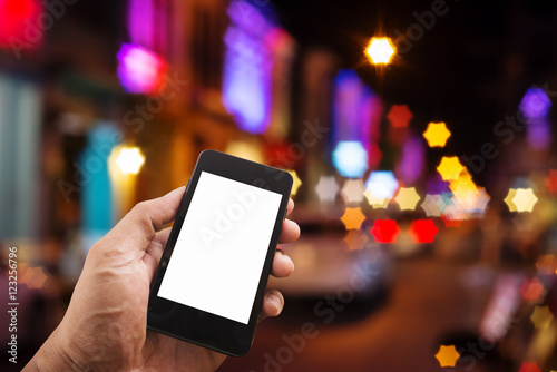 Hand man with smart phone mobile on night city