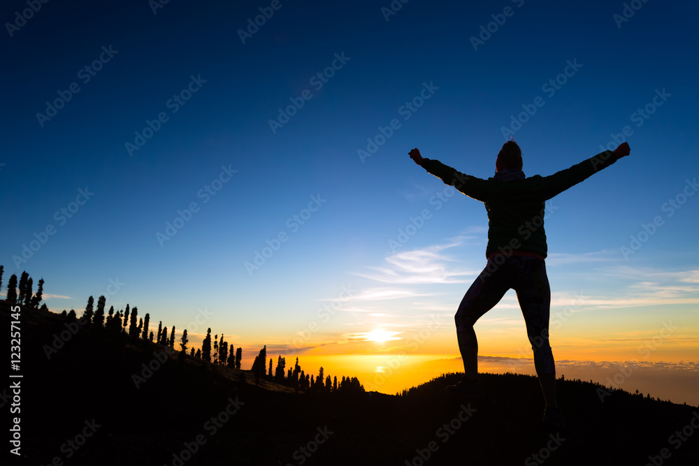 Woman hiker with arms outstretched enjoy mountains