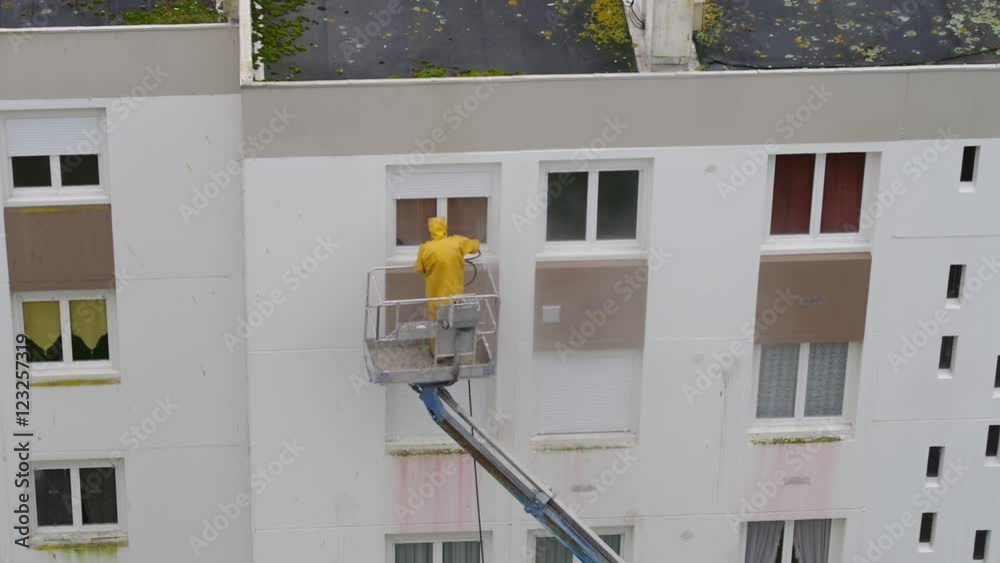 Homme utilisant un nettoyeur haute pression sur une nacelle