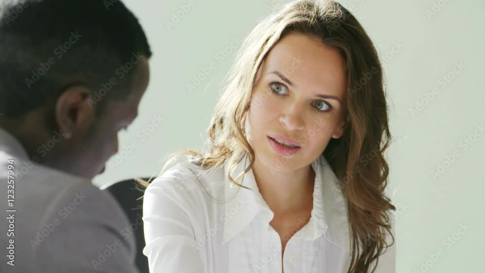 An attractive young businesswoman are having a conversation with her collegue in a bright, modern office building. They are bathed in sunlight which is streaming through the windows. In slow motion An attractive young businesswoman are having a conversation with her collegue in a bright, modern office building. They are bathed in sunlight which is streaming through the windows. In slow motion