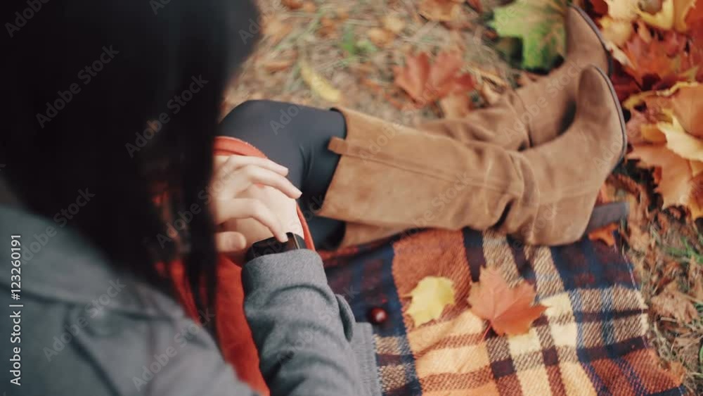 Beautiful, stylish, young womam uses smart clock sitting on plaid in autumn park. 4k Beautiful, stylish, young womam uses smart clock sitting on plaid in autumn park. 4k