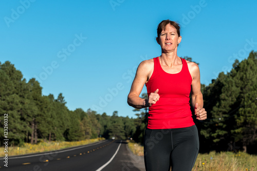 Female over forty running in countryside.