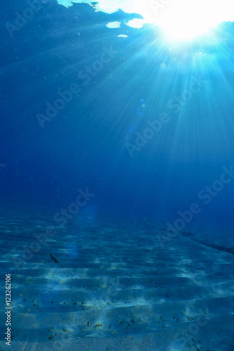 Underwater scene with sand and sunlight
