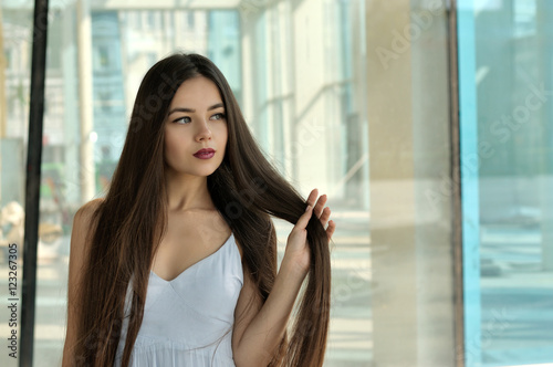 Beautiful girl holding her hair on a bent arm