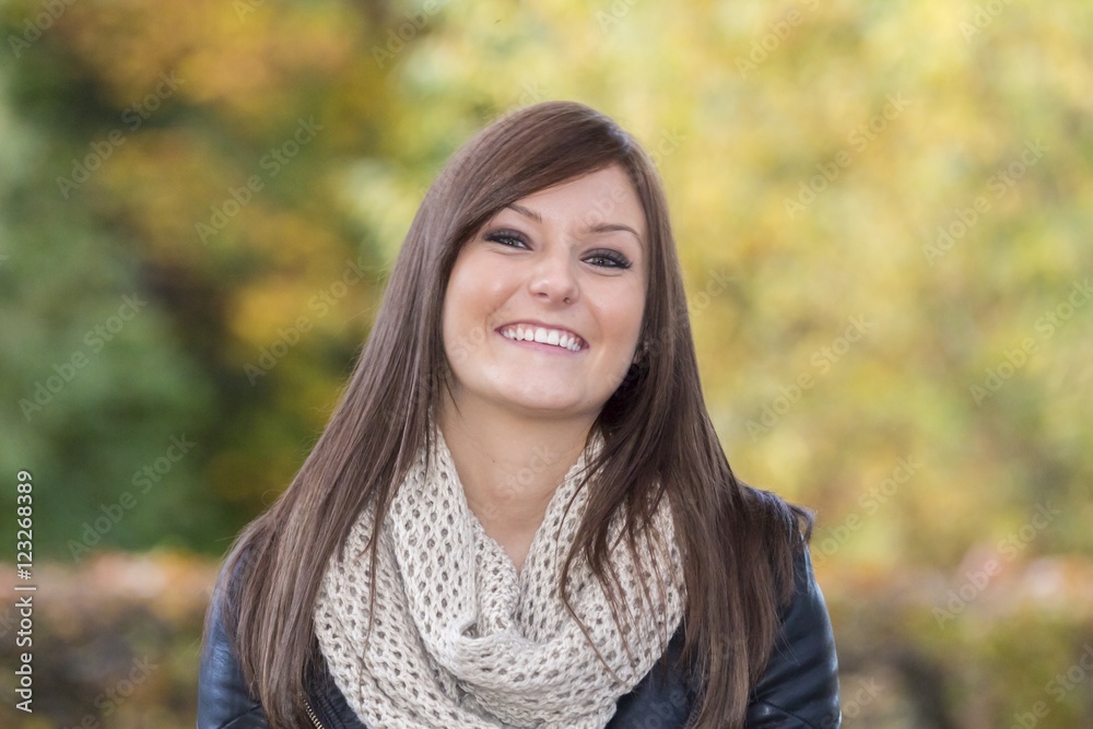 Beautiful woman with a wonderful smile. Portrait of an attractive young adult at a european park in autumn. With a nice colorful background and copy space Beautiful woman with a wonderful smile. Portrait of an attractive young adult at a european park in autumn. With a nice colorful background and copy space
