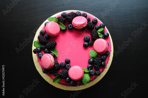 Delicious raspberry cake with fresh blueberry and blackberry on wooden background