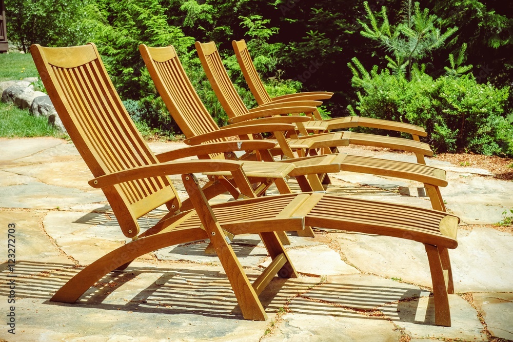 Empty patio with wood chairs lined up and ready for sunbathers a