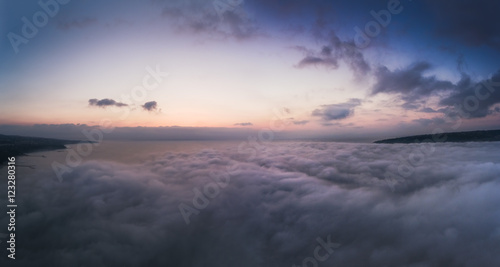 Aerial view over the sea  flying above the clouds.