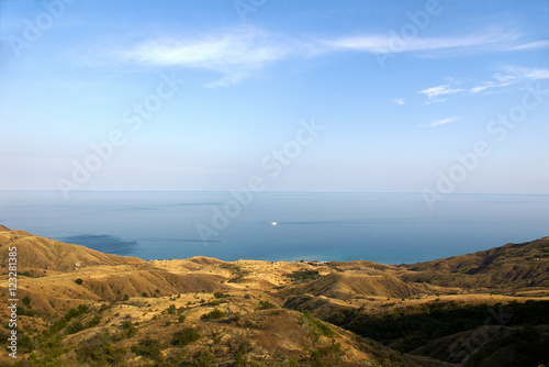 Colorful highland landscape of a deep blue sea on the background of rocky mountains under blue clear sky.Crimean mountains landscape in the summer season