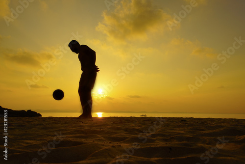 Silhouettes of footballers on the sunset sky.  photo