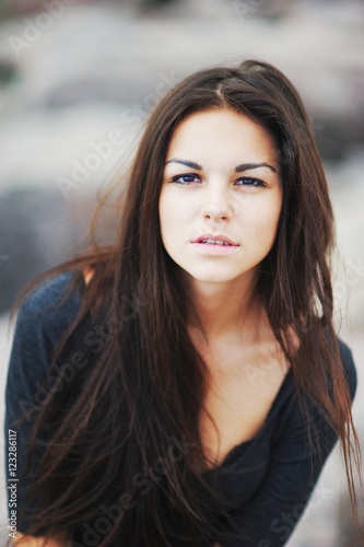 Portrait of beautiful dark-haired young woman on blurred backgro