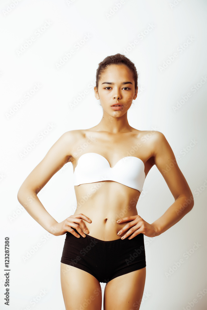 Foto de young pretty african american girl in sport underwear posing on  white background, very slim loosing weight half asian multi races woman  model, lifestyle people concept do Stock