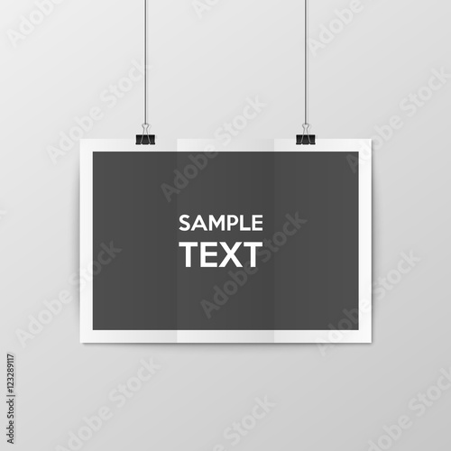 Sheet of folded paper hangs on the clamps.