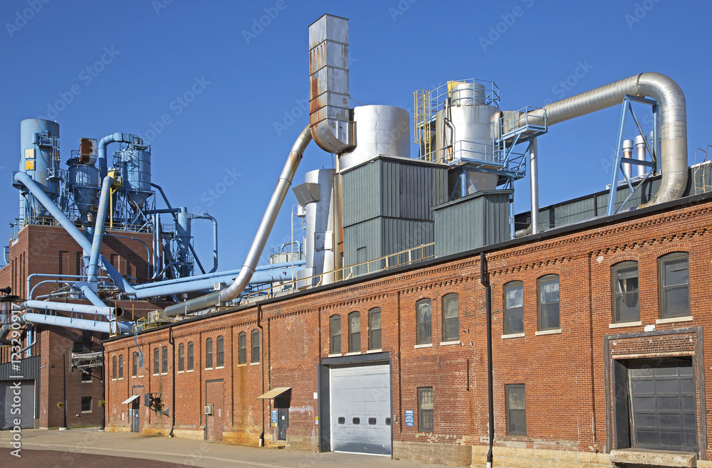 Dubuque Iowa, October 2016: A manufacturing plant in the historic Millwork District of Dubuque, Iowa sits under a blue sky on a warm October day. Dubuque Iowa, October 2016: A manufacturing plant in the historic Millwork District of Dubuque, Iowa sits under a blue sky on a warm October day.