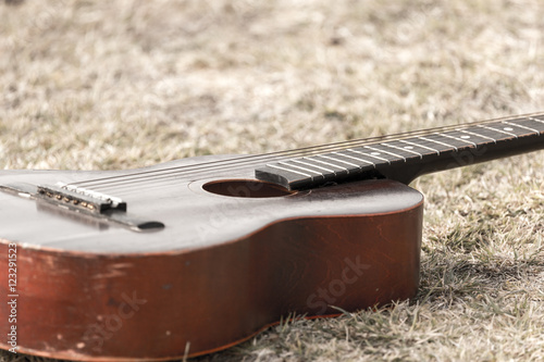 Guitar lying on the grass on the nature photo