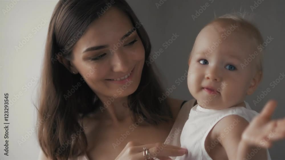 Happy family laughing faces, mother holding adorable child baby boy, smiling and hugging, close up border, beauty of smile, female isolated on white, healthy kid joyful mom, expressing love emotions Happy family laughing faces, mother holding adorable child baby boy, smiling and hugging, close up border, beauty of smile, female isolated on white, healthy kid joyful mom, expressing love emotions