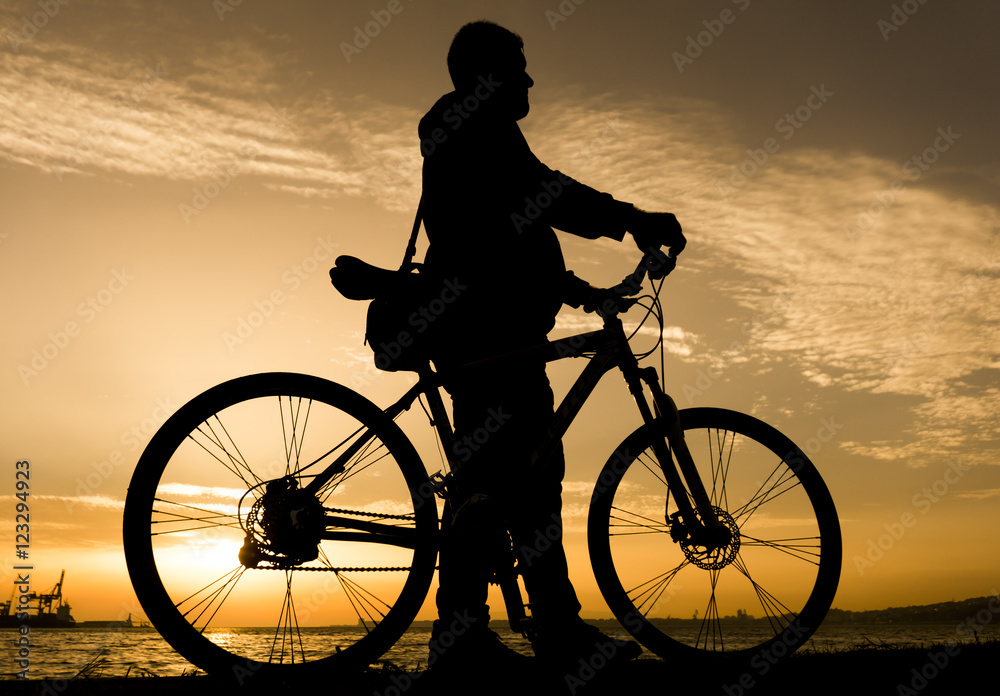 Obraz premium Silhouettes of biking man at beautiful sunset