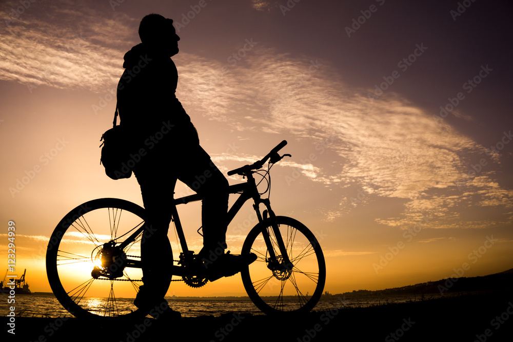Obraz premium Silhouettes of biking man at beautiful sunset