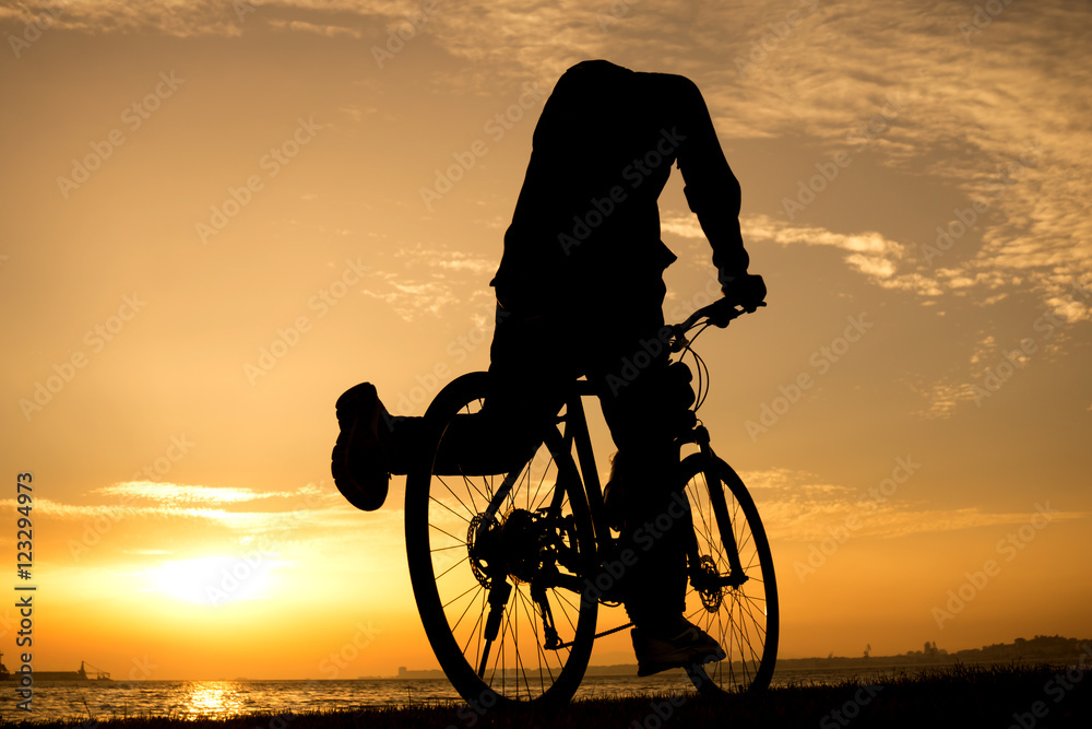 Obraz premium Silhouettes of biking man at beautiful sunset