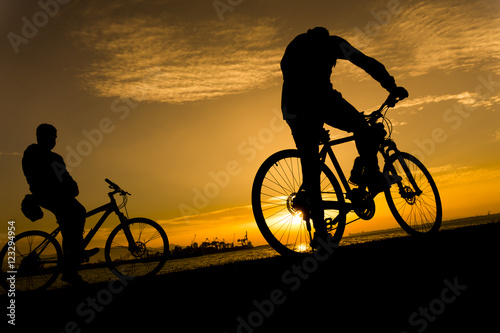 Silhouettes of biking man at beautiful sunset