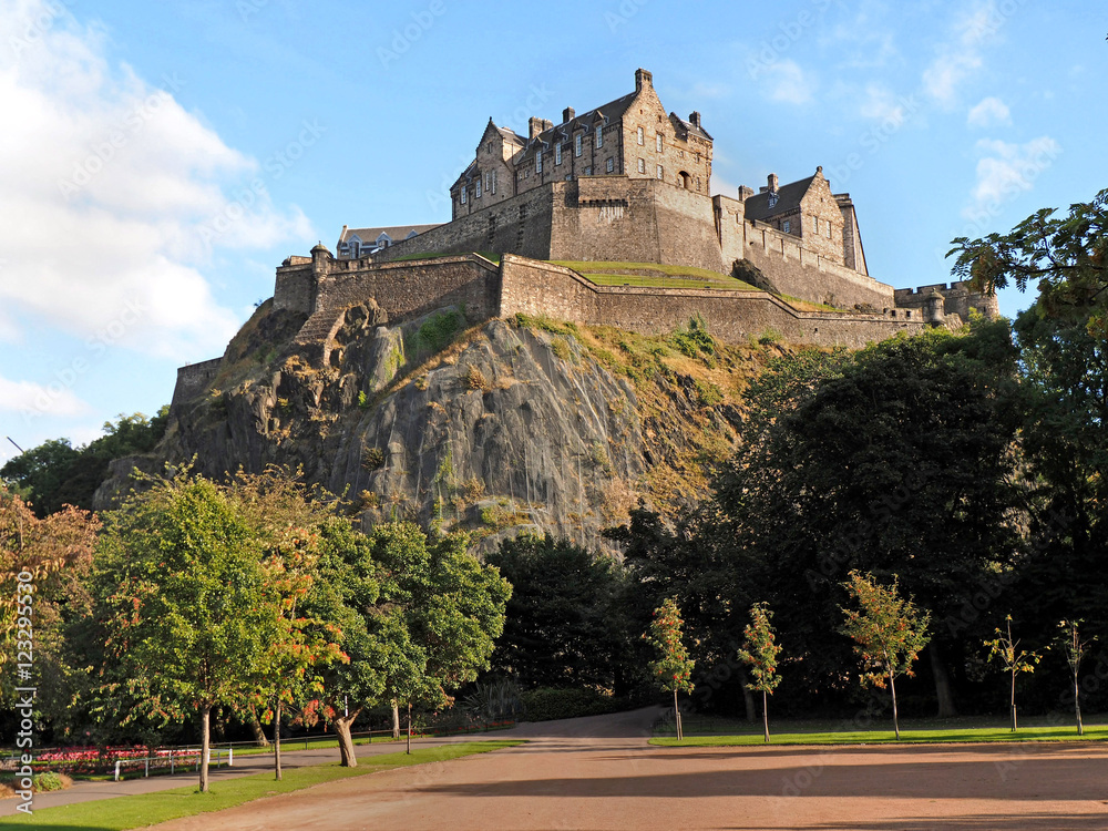 Edinburgh Castle rock rising above Princes Street Gardens foto de Stock Adobe Stock