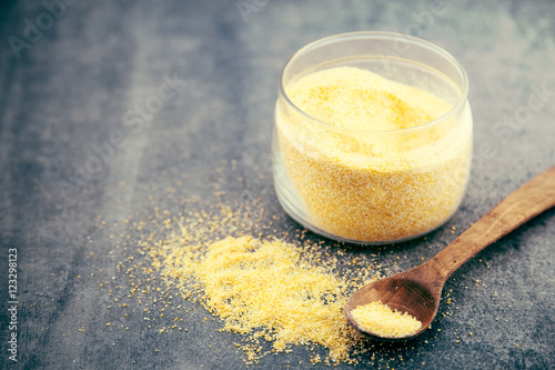 Yellow corn flour in a glass jar on a rustic table. Ingredients photo