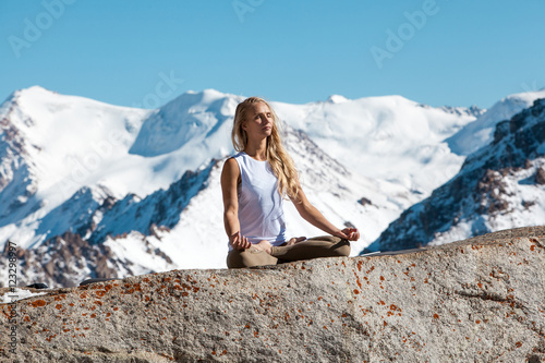 Woman is practicing yoga against Kazakhstan mountains. © Pitcher