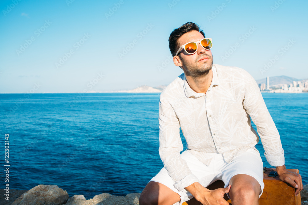 Stylish man in sunglasses enjoying in sunlight