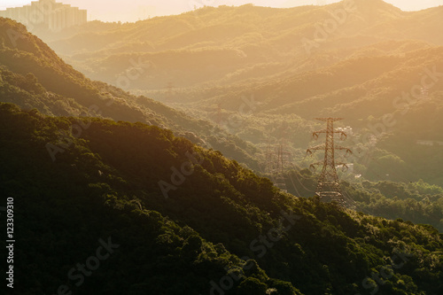 High voltage transmission towers With mountains behind,sunset ti