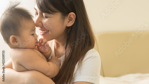 Happy mother holding adorable child baby boy..
