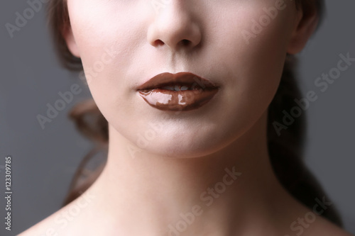 Girl with chocolate lips, closeup photo