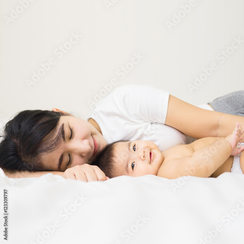 happy family.asian  mother playing with her baby in the bedroom.