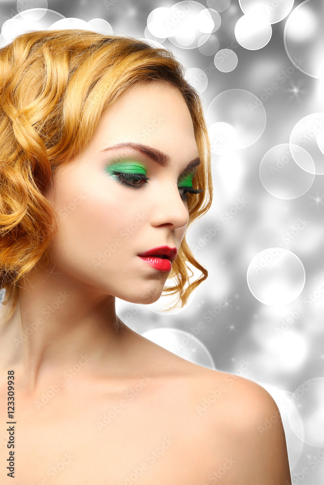 Beautiful girl with colorful makeup and hairstyle on shiny blurred background Beautiful girl with colorful makeup and hairstyle on shiny blurred background