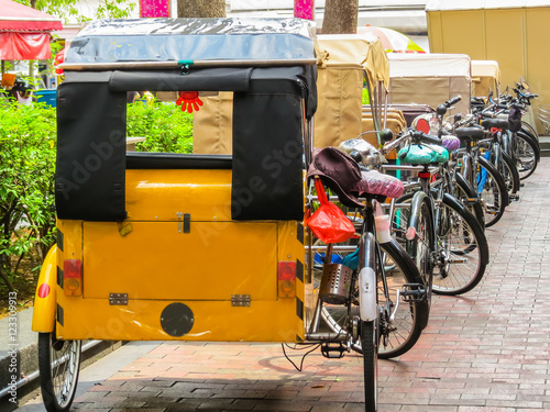Trishaws expect passengers on the street of Singapore photo