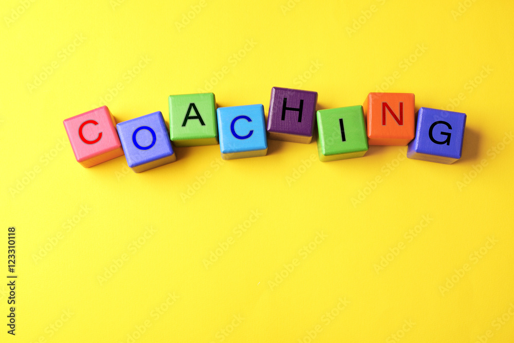 Coaching concept. Wooden cubes on yellow background Coaching concept. Wooden cubes on yellow background