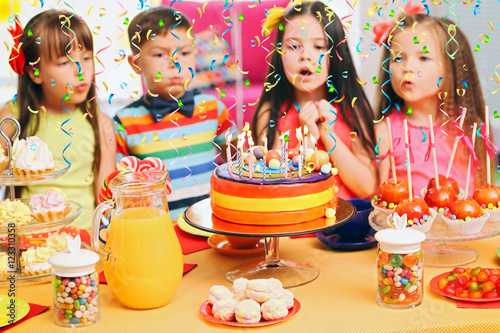 Children blowing candles on...