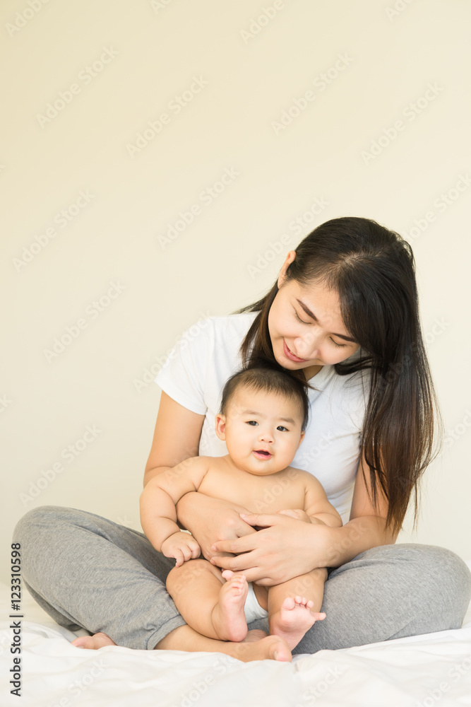 happy family.asian  mother playing with her baby in the bedroom.
