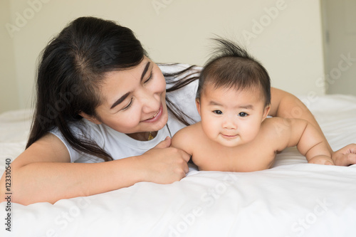 happy family.asian  mother playing with her baby in the bedroom.