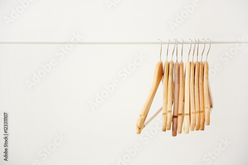 Wooden coat hangers on clothes rail and white background