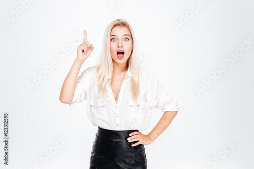 Portrait of a smiling young beautiful businesswoman pointing finger up