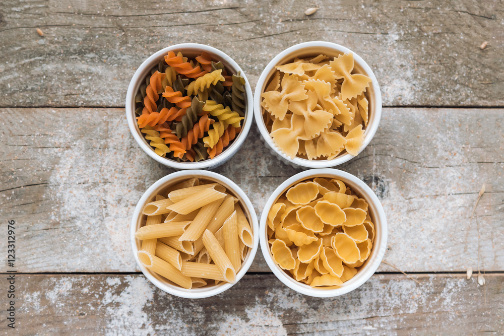 Various types of pasta on wooden rustic background