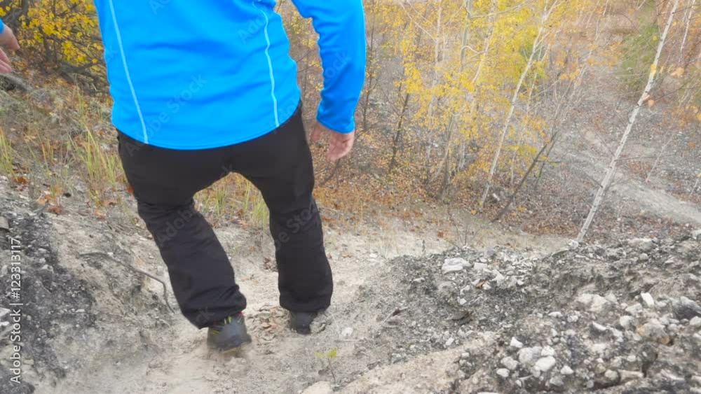 Running man trail runner in cross-country training run. Male athlete sports runner jogging downhill in forest outdoor autumn. Slow Motion. Running man trail runner in cross-country training run. Male athlete sports runner jogging downhill in forest outdoor autumn. Slow Motion.