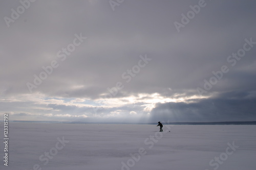 Fisherman on the river covered with ice